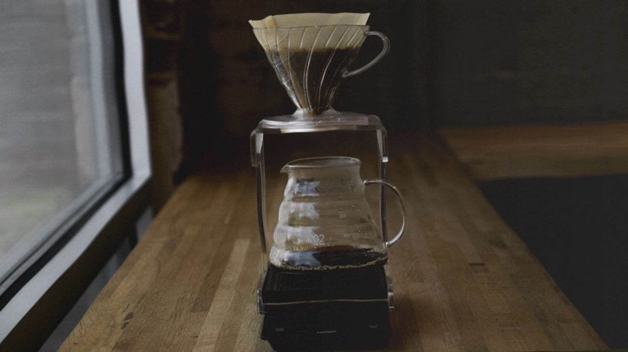 Geöffnete Kaffeetüte mit Bohnen im Probenbecher